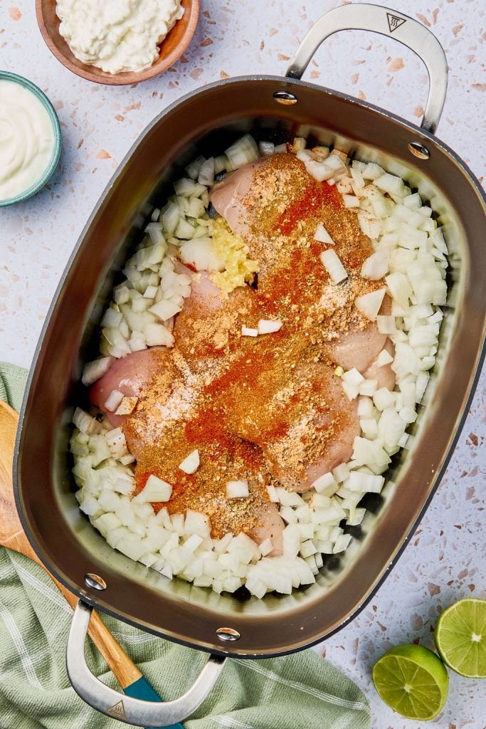 seasoned chicken added to crockpot with onions