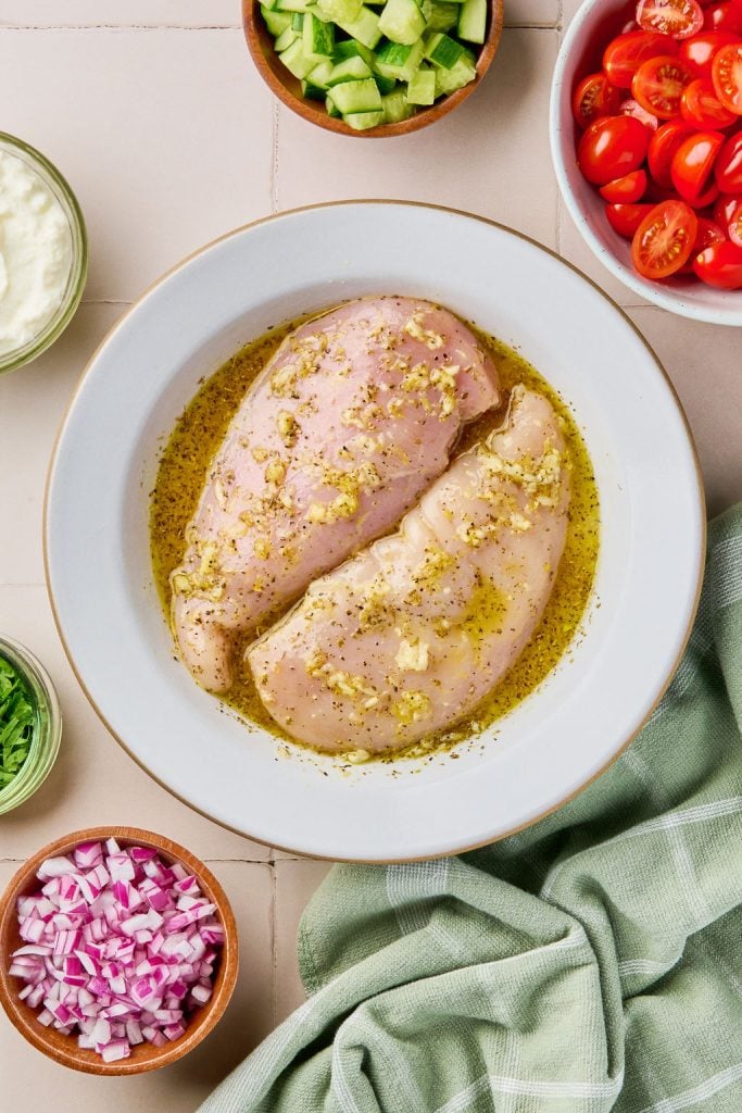 the chicken breasts marinating in a bowl