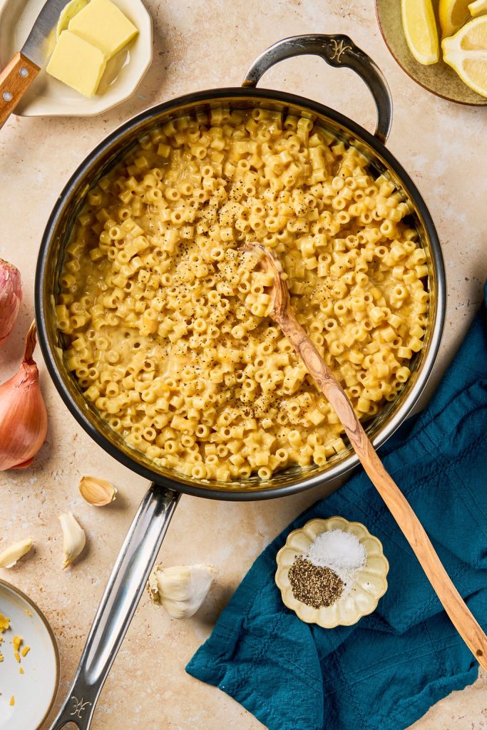 Mac and cheese in a skillet with salt and pepper added