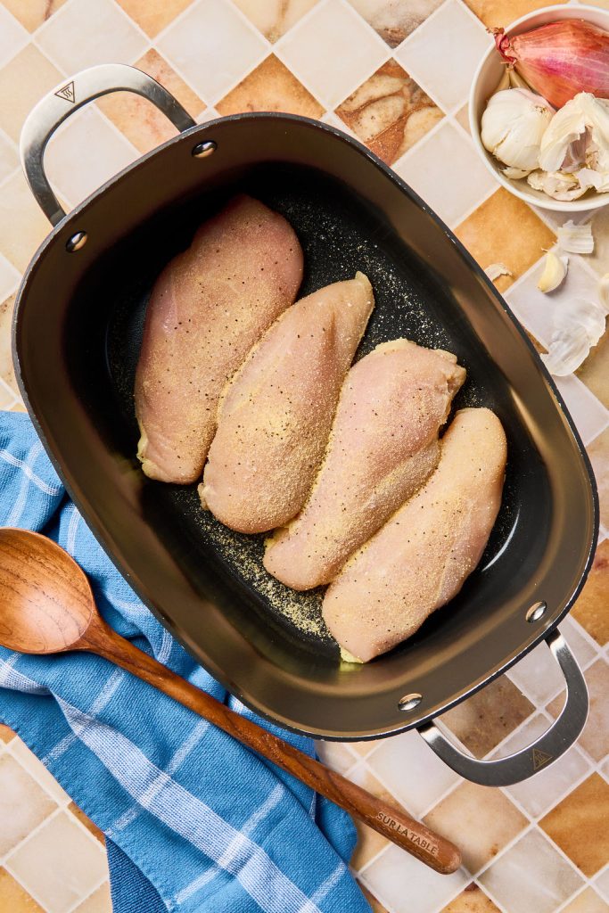 chicken breasts in a crockpot topped with seasonings