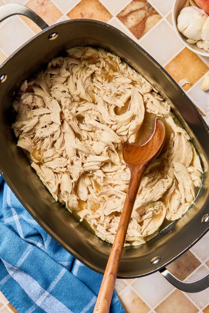 shredded chicken in crockpot with wooden spoon
