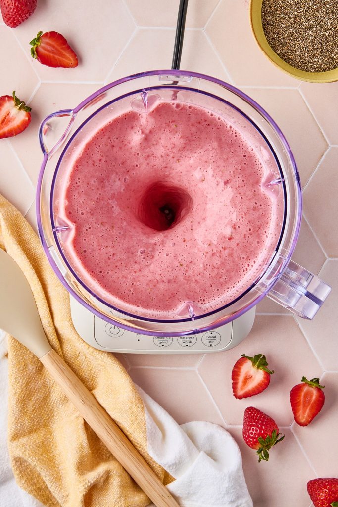 strawberries, milk, honey, vanilla, and salt blending in a blender