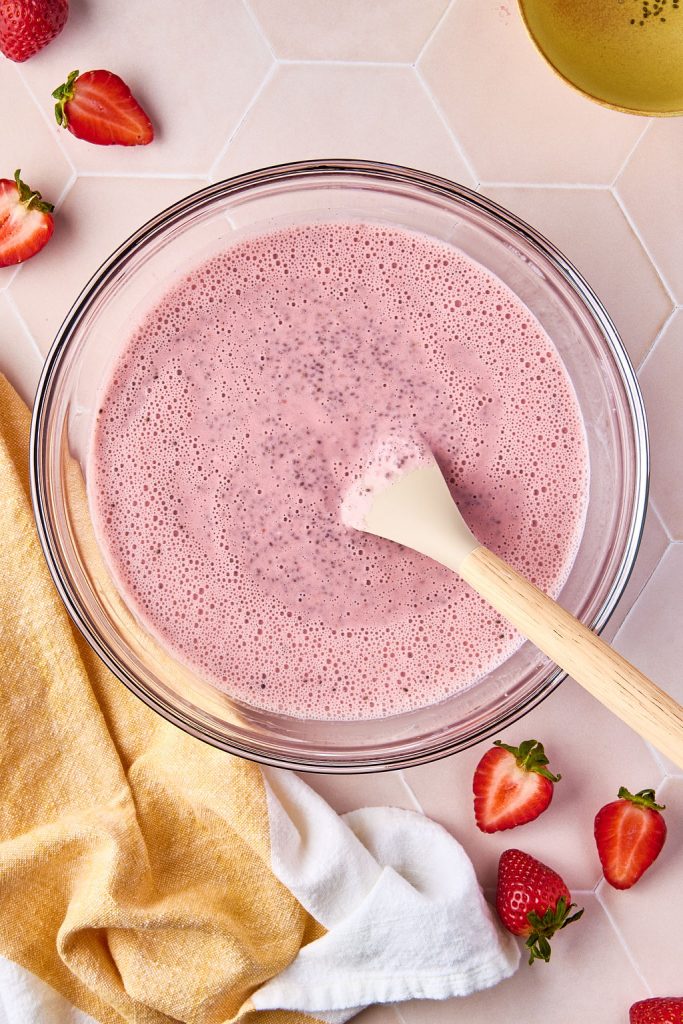 chia seeds mixed in pudding with a wooden spoon