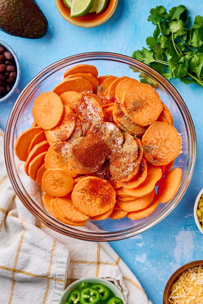 sweet potato rounds in a bowl with seasonings