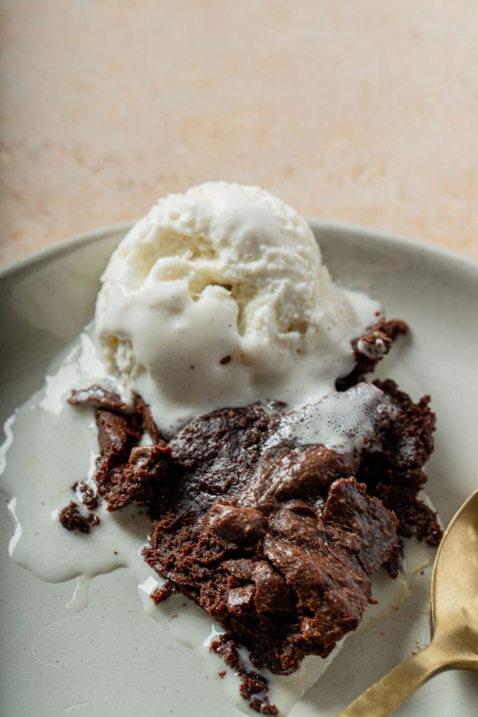 brownie pudding on a plate with ice cream