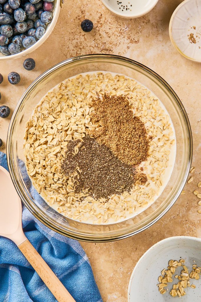 oats, chia seeds, and ground flaxseed added to glass bowl