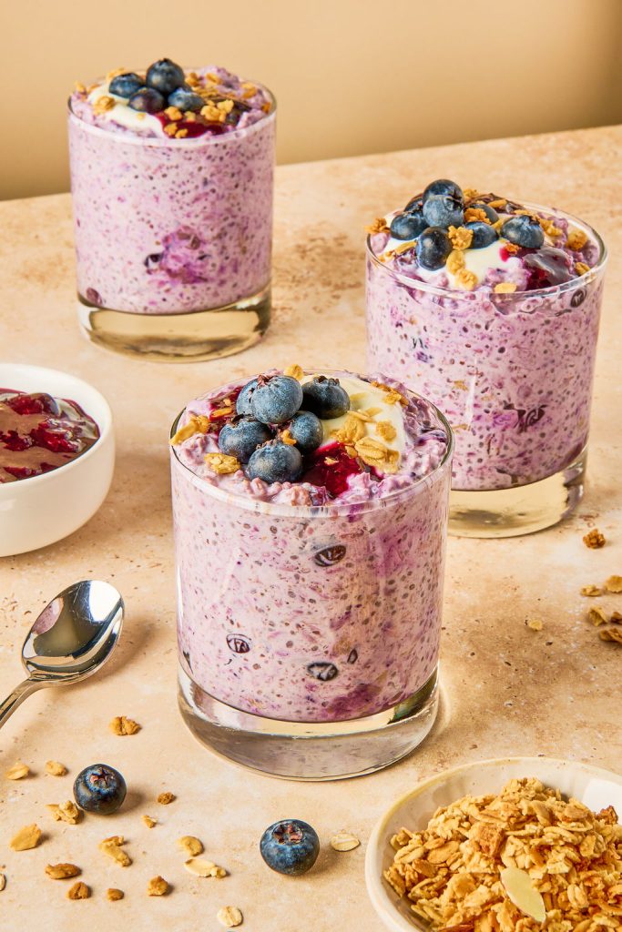 blueberry oats in glasses topped with fresh blueberries and oats