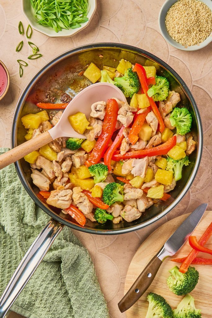 pineapple added to chicken and veggies in skillet