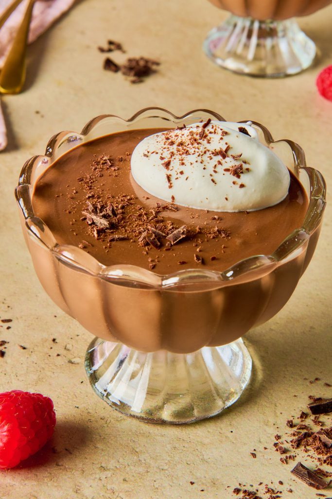 chocolate cottage cheese mousse in a glass bowl topped with whipped cream