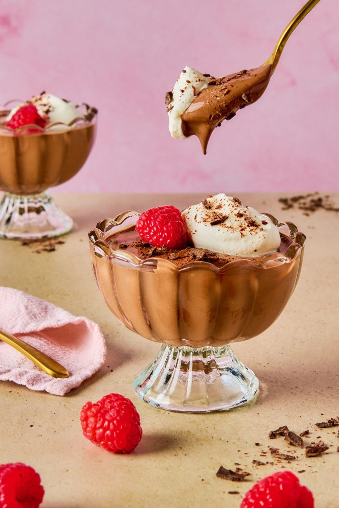 chocolate cottage cheese mousse topped with whipped cream and a raspberry