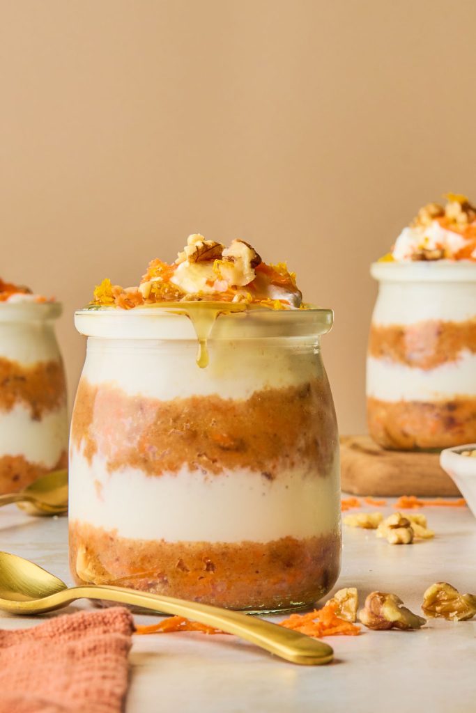 carrot cheesecake jars topped carrot shreds, nuts and whipped cream