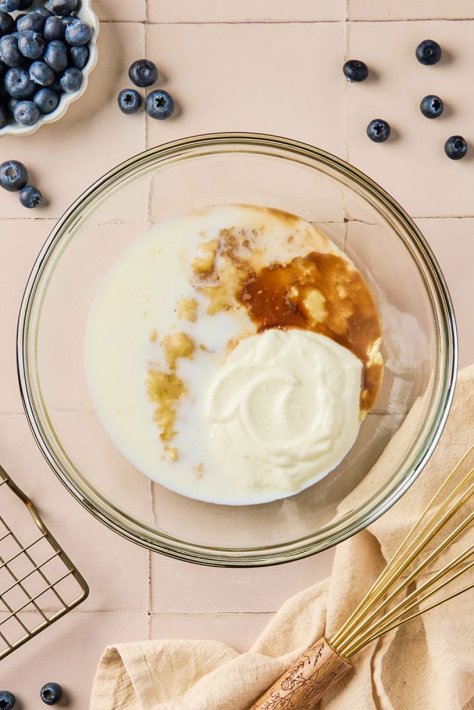Greek yogurt, vanilla extract, and milk in a glass bowl