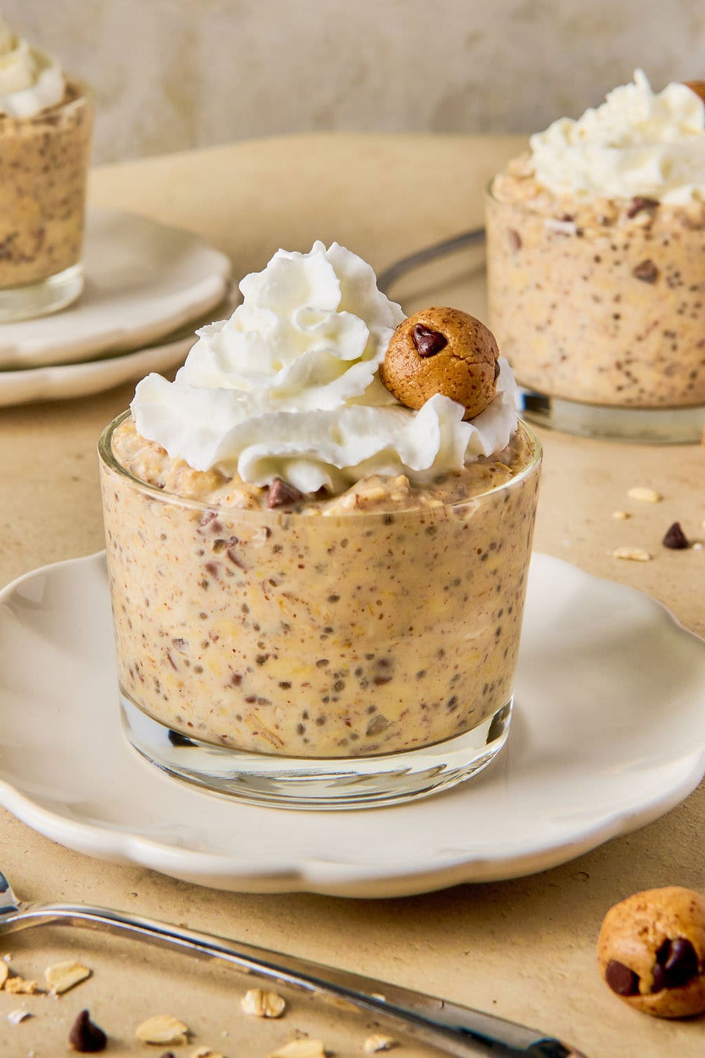 cookie dough overnight oats topped with whipped cream and bite sized cookie dough balls