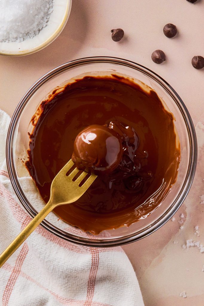 truffle being dipped in chocolate using gold fork