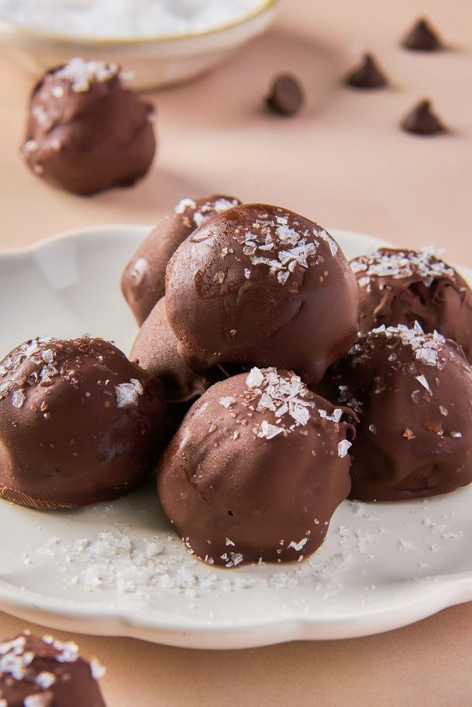 flaky sea salt added to pile of truffles on a plate