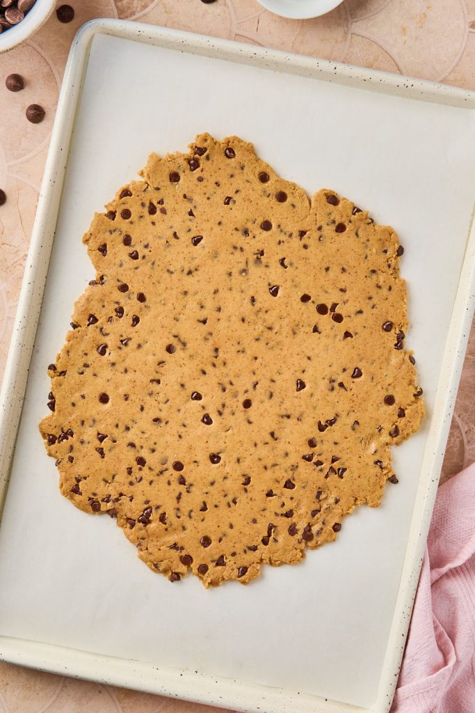 cough dough pressed into parchment paper on baking sheet