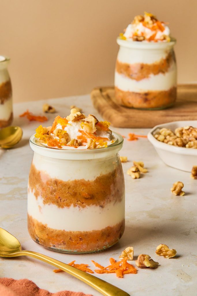 carrot cheesecake jars topped carrot shreds, nuts and whipped cream