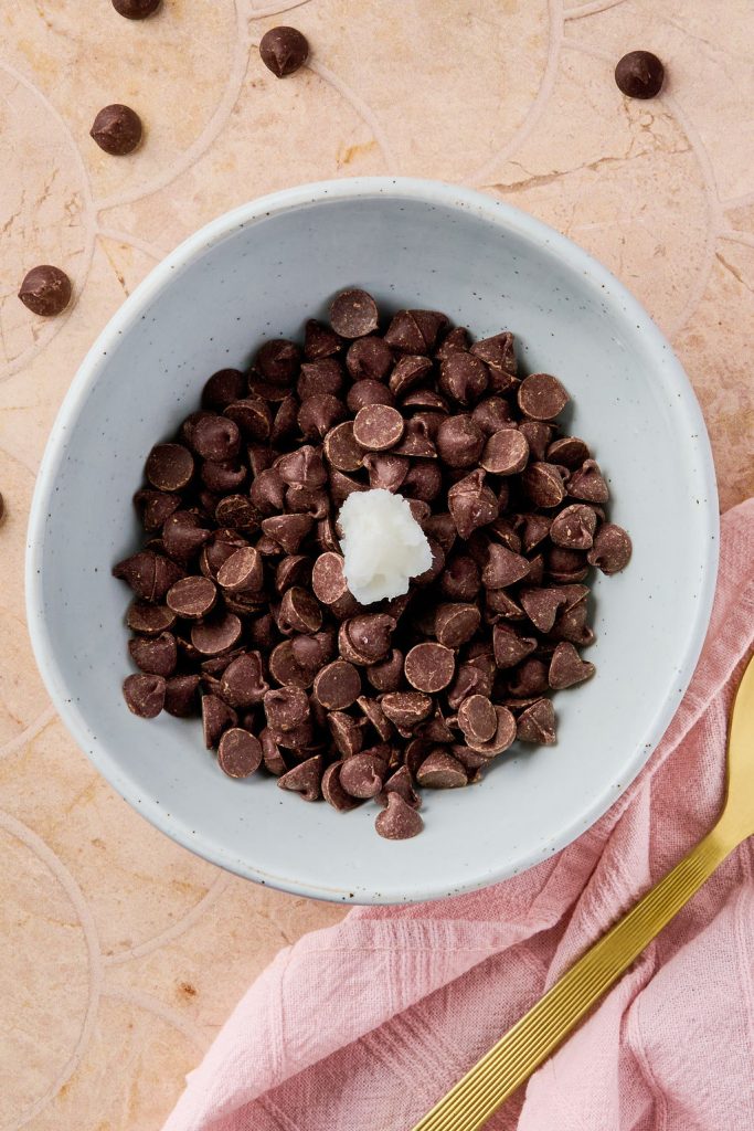 coconut oil added to chocolate chips in bowl