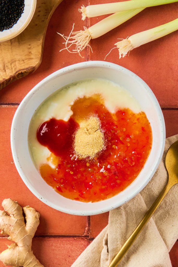 Greek yogurt, sweet chili sauce, sriracha, rice vinegar, honey, garlic powder, and water/milk in a bowl
