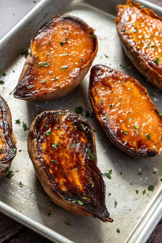 caramelized sweet potato halves on a baking sheet
