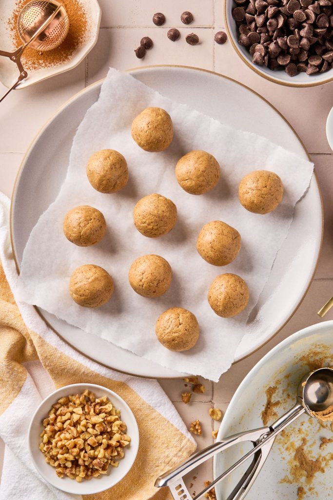 banana bread bites rolled into balls and placed on parchment paper on a plate