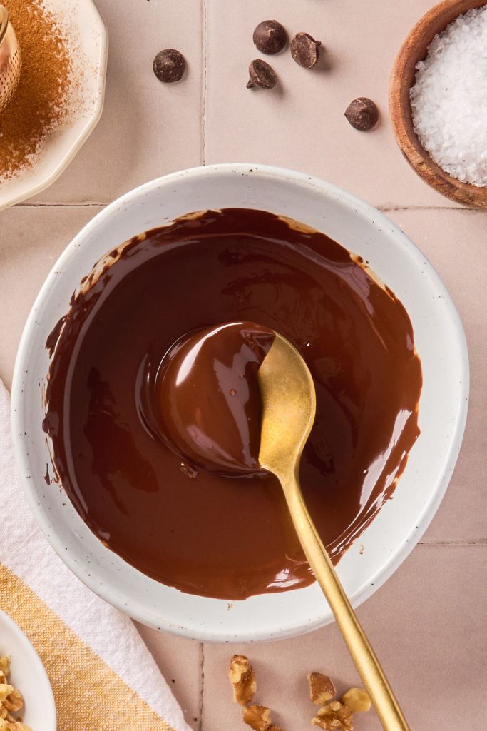 melted chocolate in a bowl with a gold spoon