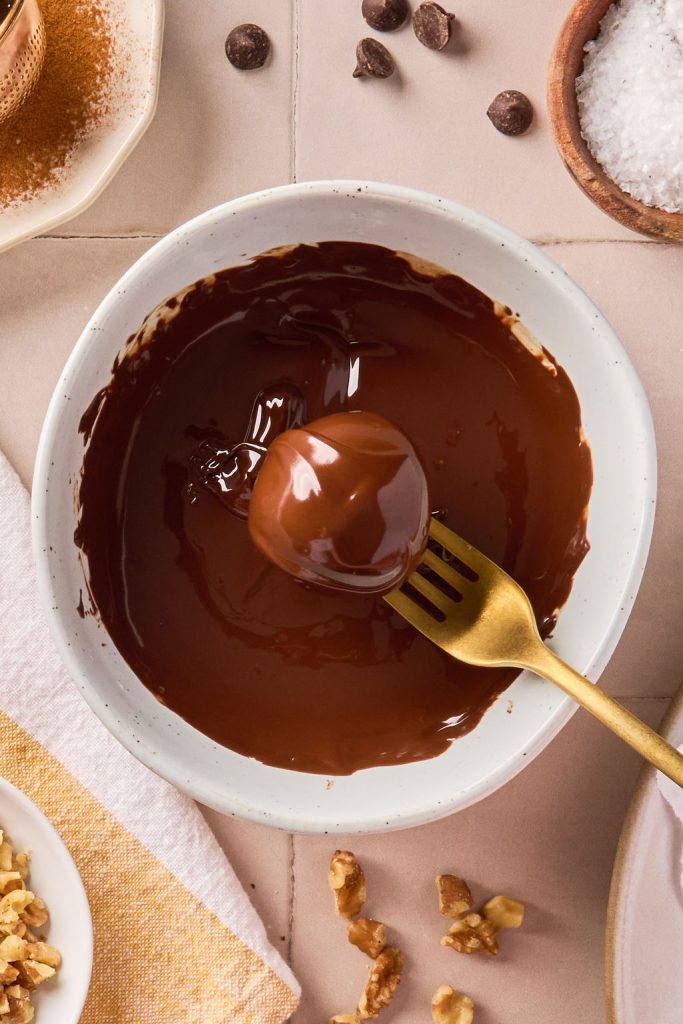 banana bread bite dipped in melted chocolate with a fork
