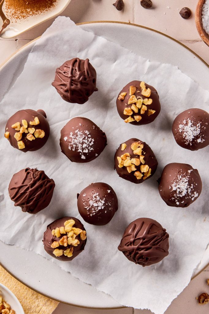 banana bread bites coated in chocolate and topped with salt, nuts or drizzled chocolate