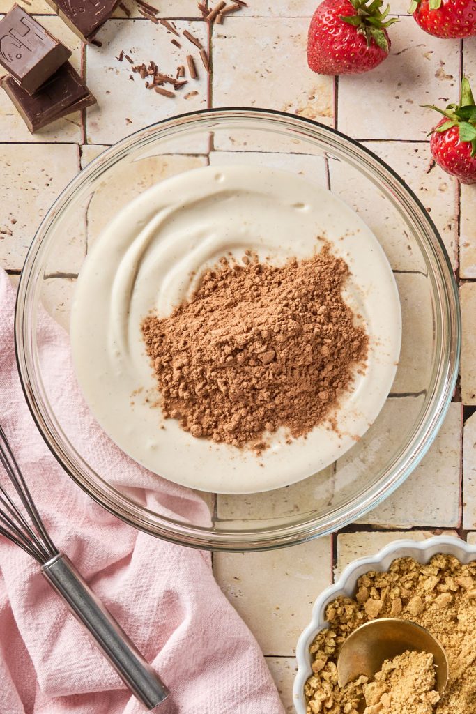 cocoa powder added to cheesecake mixture in a bowl