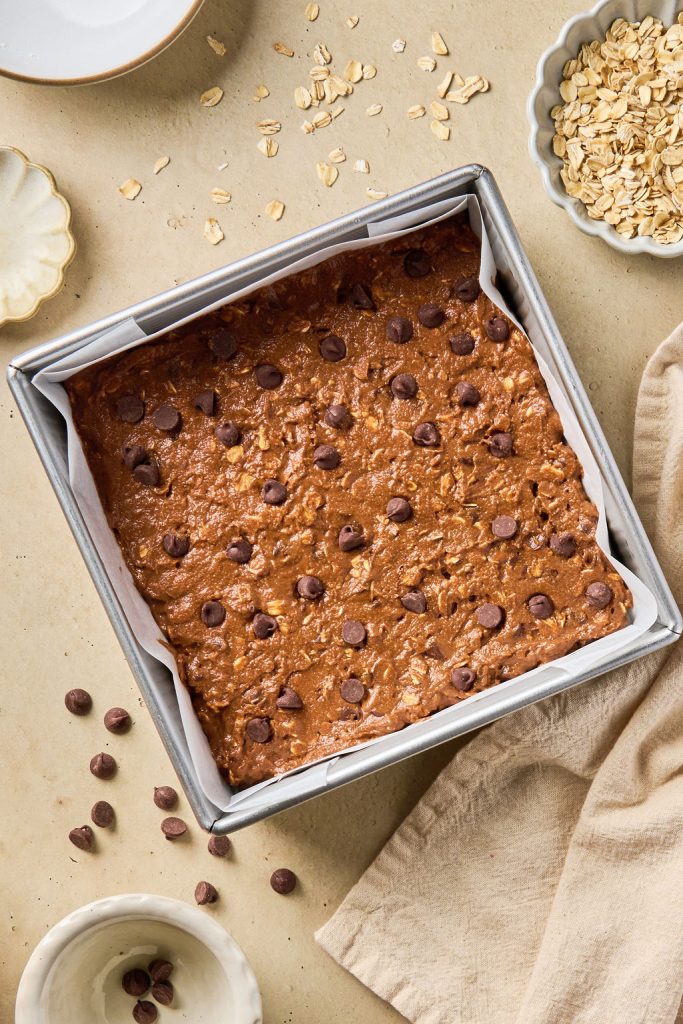 batter in baking tray with chocolate chips added to the top
