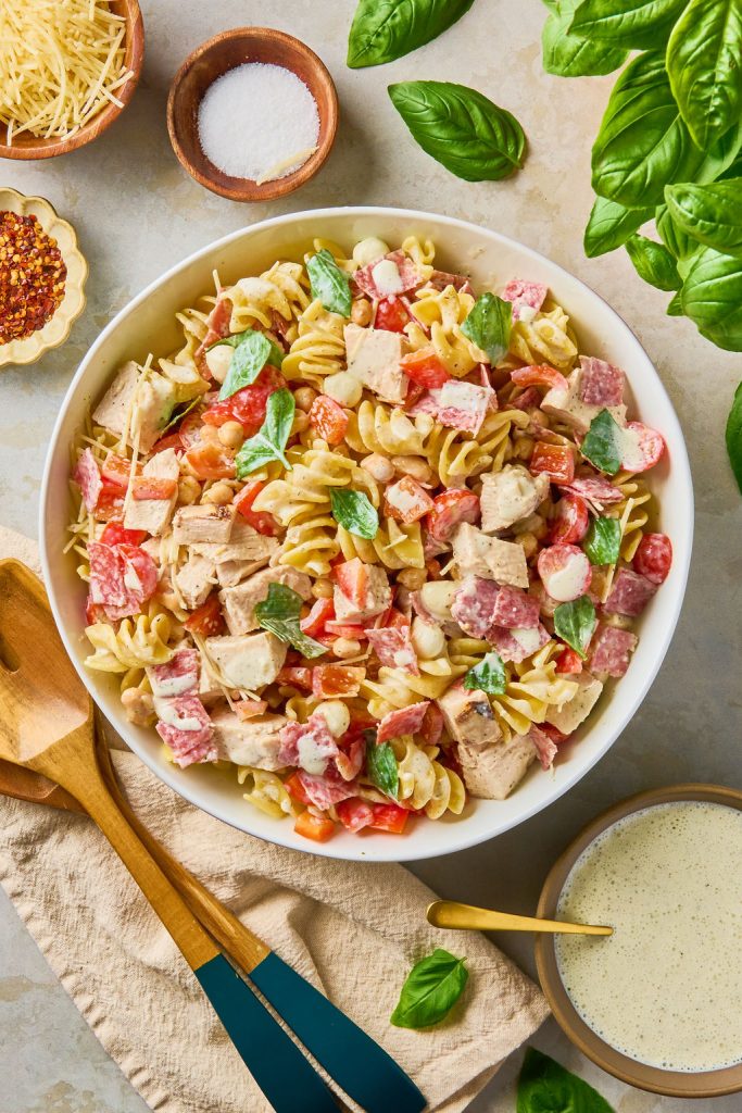 high protein pasta Salad in a bowl with 2 wooden serving spoons