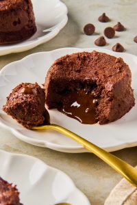 chocolate cottage cheese lava cake with a scoop out of it to show the inside on a plate