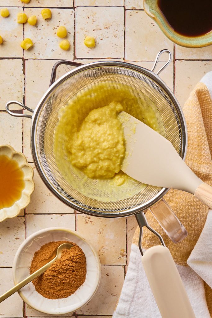 blended corn being strained through a fine mesh sieve
