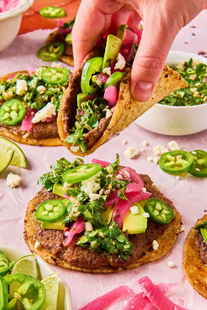 close up of chimichurri smashed taco being picked up