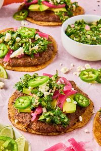 chimichurri smashed tacos topped with picked onions, jalapeños and chimichurri sauce