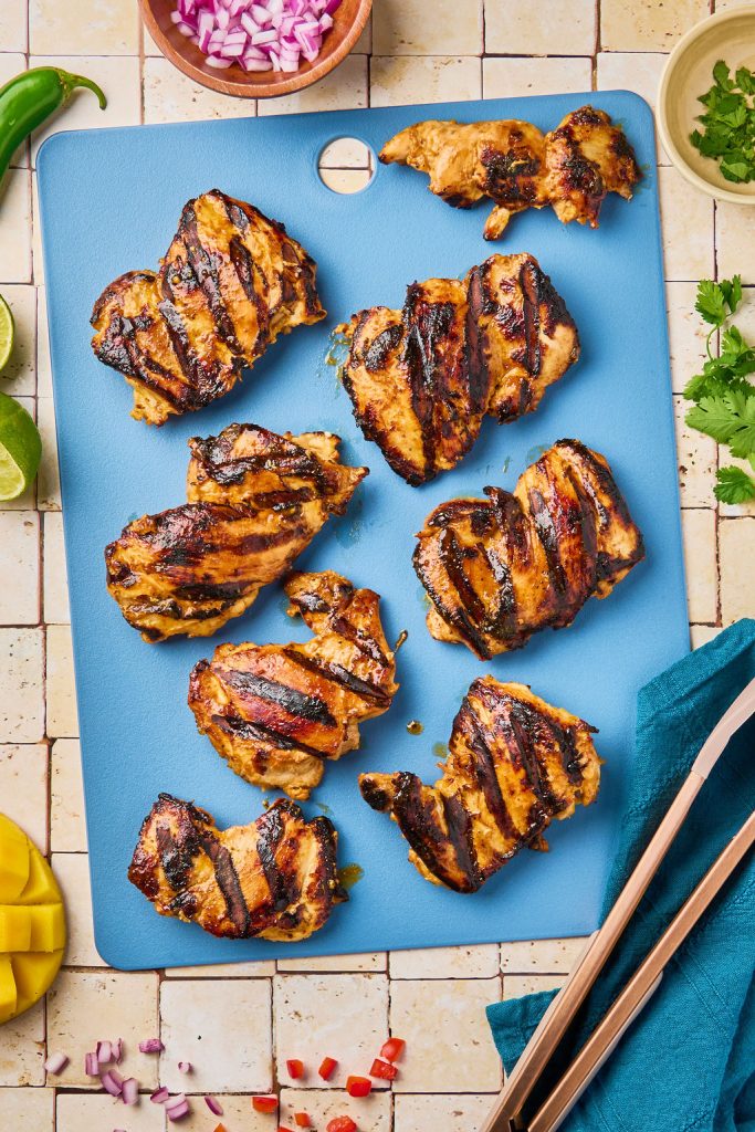 cooked marinated mango chicken on a cutting board