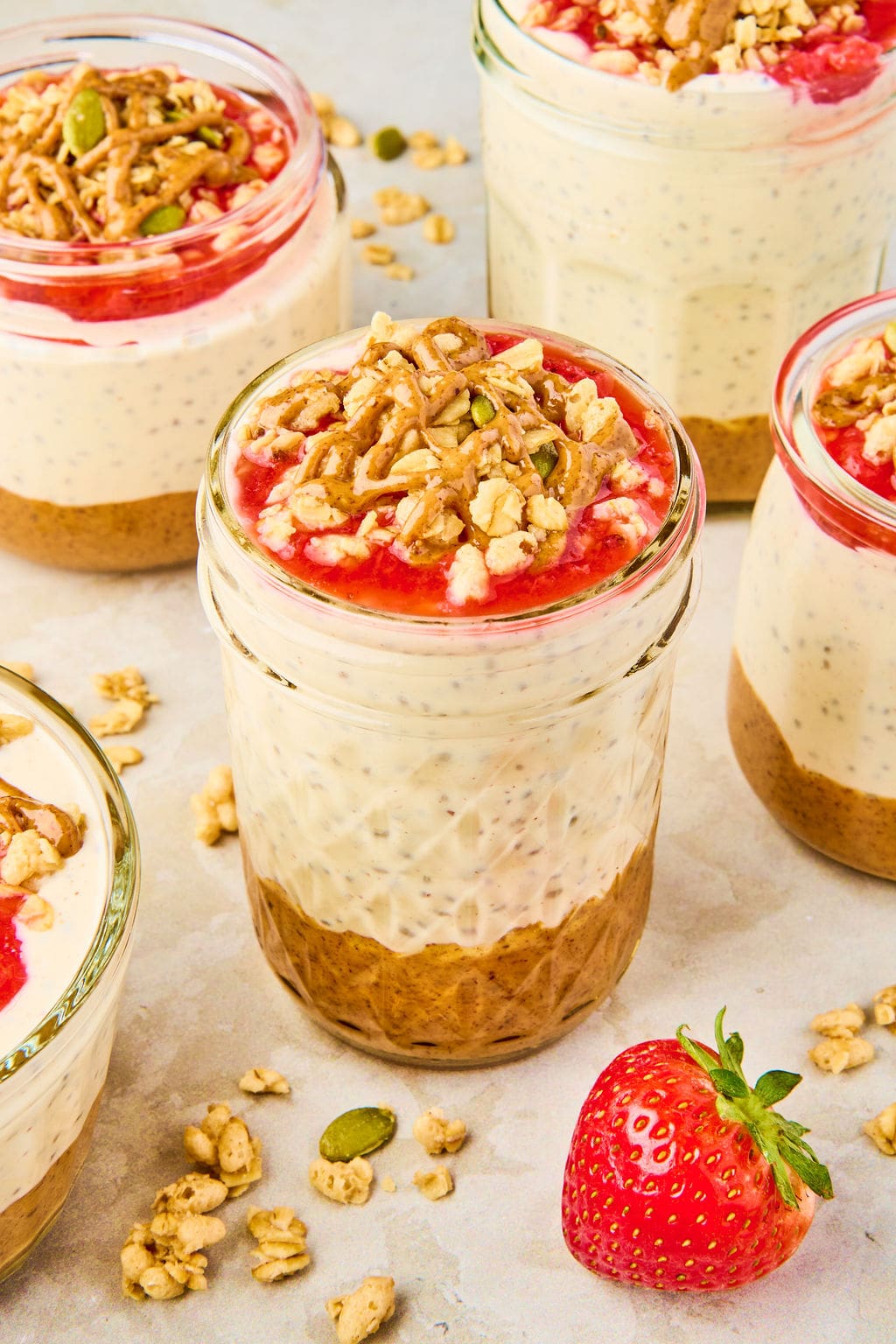 peanut butter and jelly chia pudding in a jar, topped with peanut butter and granola
