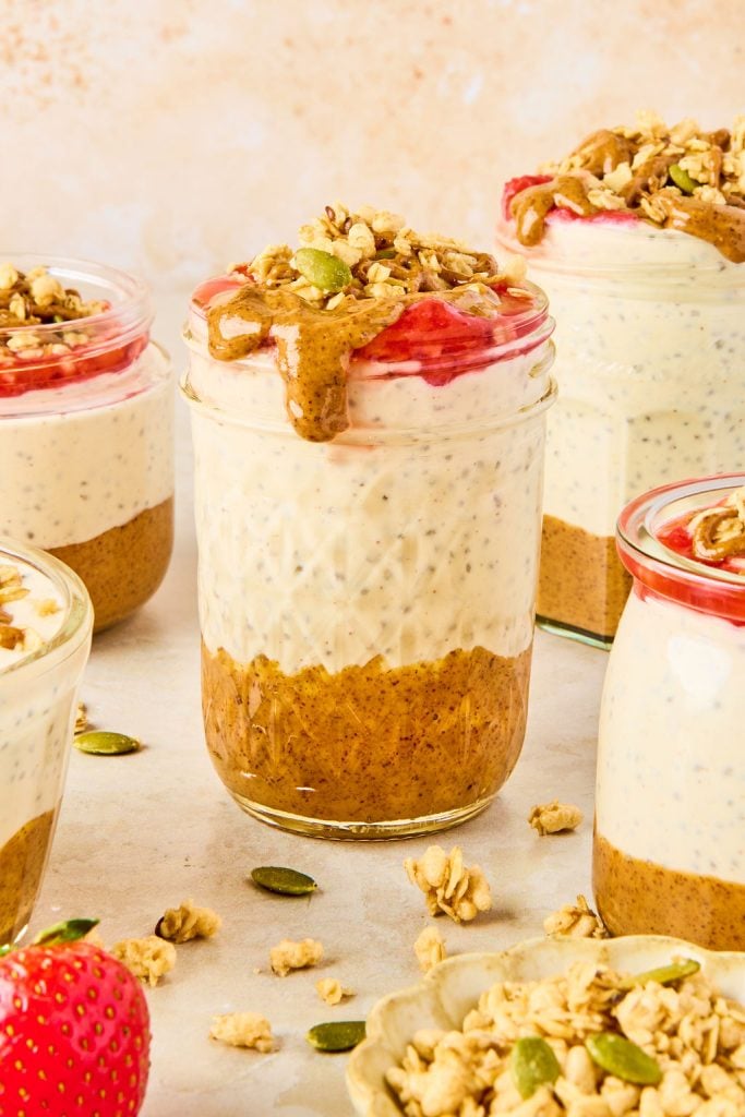 peanut butter and jelly chia pudding in a jar, topped with peanut butter and granola