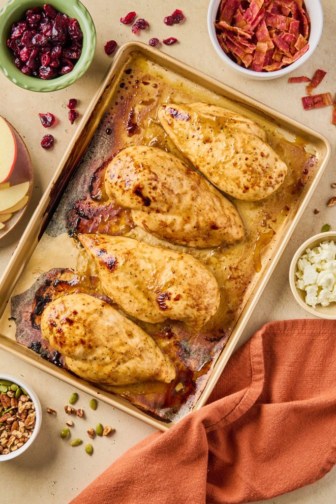 cooked chicken breasts on a baking sheet