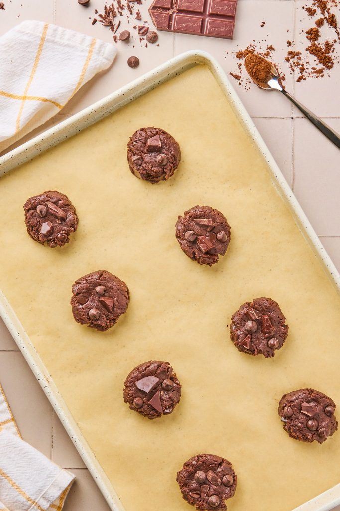 chocolate chips and chopped chocolate pieces added to the top of the flatted cookie dough