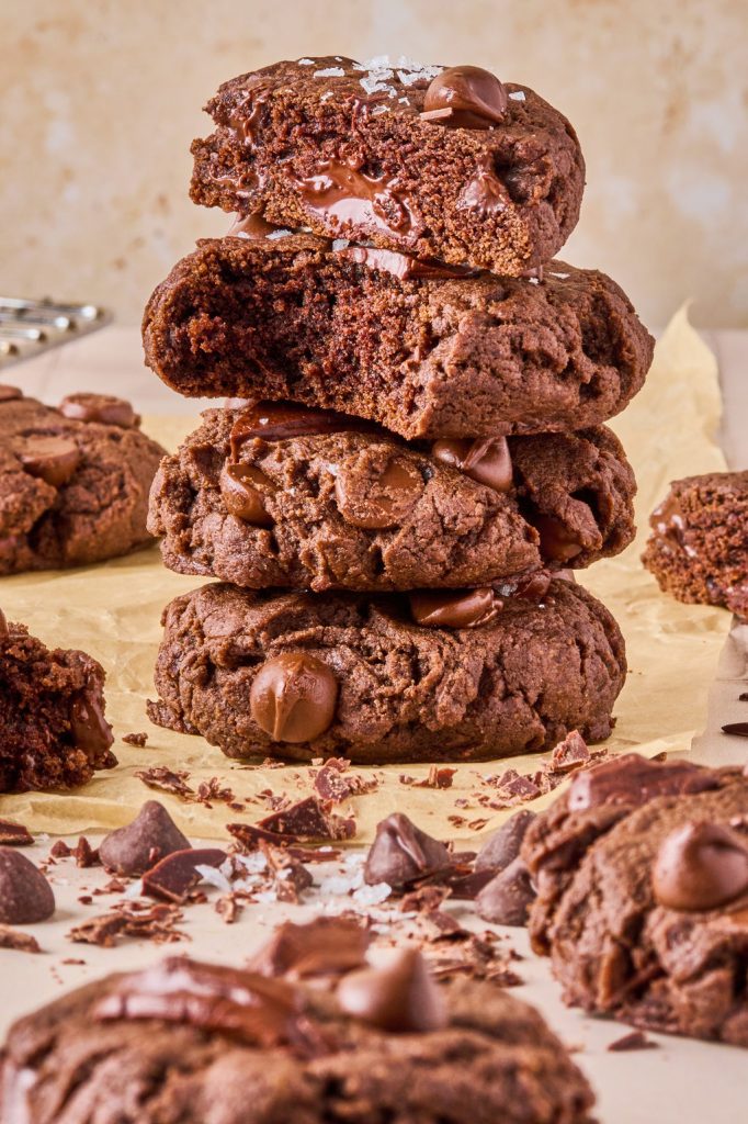 brownie batter tahini geek yogurt cookies stacked 4 high with a couple bites taken out of the cookies