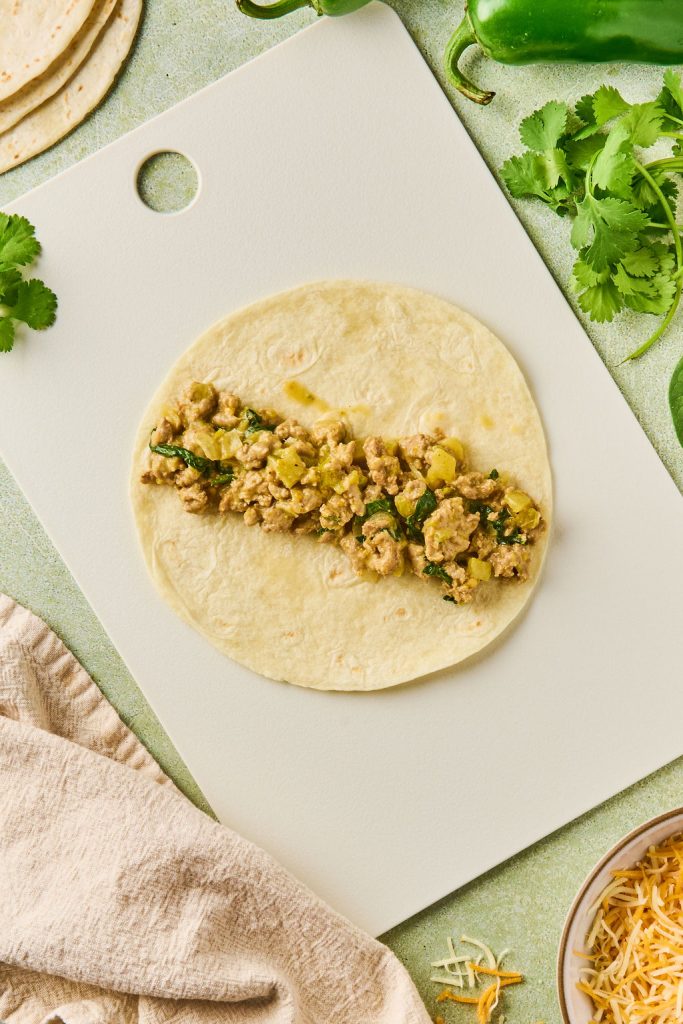 enchilada filling placed on the middle of a tortilla