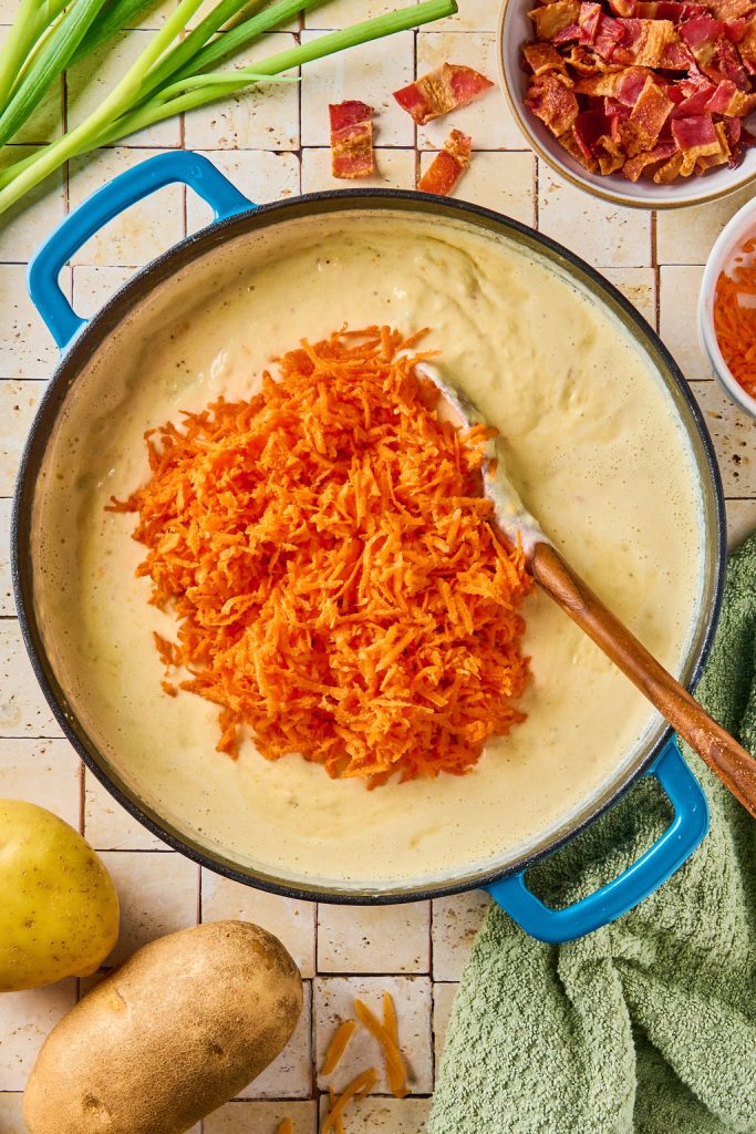 shredded carrots added to the potato soup